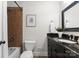 Well-lit bathroom featuring a bathtub with a shower, dark vanity, and decor at 1700 Emerywood Dr, Charlotte, NC 28210