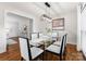 Dining room features a glass top table, white chairs, hardwood floors, and modern lighting at 1700 Emerywood Dr, Charlotte, NC 28210