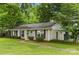 Classic ranch home with a brick facade, a walkway, black shutters, and lovely green landscaping at 1700 Emerywood Dr, Charlotte, NC 28210