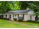 Classic home with a well-maintained lawn, tidy garden beds and a bright blue front door at 1700 Emerywood Dr, Charlotte, NC 28210