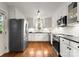 Bright renovated kitchen boasts stainless steel appliances, hardwood floors and white cabinets at 1700 Emerywood Dr, Charlotte, NC 28210