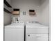 Functional laundry room featuring a side-by-side washer and dryer unit with shelf storage at 1700 Emerywood Dr, Charlotte, NC 28210