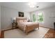 This sunny bedroom offers hardwood floors and a large window overlooking the landscaped yard at 2000 Ferncliff Rd, Charlotte, NC 28211