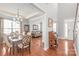 Open concept dining area with hardwood floors, elegant chandelier, and living room view at 2441 Chatham Dr, Fort Mill, SC 29707