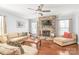 Cozy living room with a stone fireplace, hardwood floors, and comfortable seating at 2441 Chatham Dr, Fort Mill, SC 29707