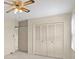 Neutral bedroom featuring a ceiling fan, large windows and a closet with louvered doors at 301 Museum Rd, Statesville, NC 28625