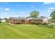 Brick home with a well-manicured lawn, flower beds and a dark shingled roof at 301 Museum Rd, Statesville, NC 28625