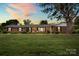 Brick home with covered porch and manicured lawn at dusk at 301 Museum Rd, Statesville, NC 28625