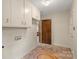 Laundry room featuring overhead cabinets, tile floors and exterior doors at 301 Museum Rd, Statesville, NC 28625
