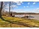 Scenic lakefront showcasing a private dock, an American flag, and lush landscaping at 3062 Bass Dr, Sherrills Ford, NC 28673