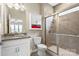Well-lit bathroom featuring a granite vanity, walk-in shower with glass door, and tiled walls at 3537 Plum St, Fort Mill, SC 29715