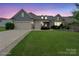 Inviting two-story home with a well-manicured lawn and a three car garage at dusk at 3537 Plum St, Fort Mill, SC 29715