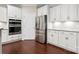 Modern kitchen featuring white cabinets, stainless steel appliances, and dark hardwood floors at 3537 Plum St, Fort Mill, SC 29715