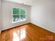 Cozy bedroom with wood floors, and a bright window at 3600 Sipes Ln, Charlotte, NC 28269