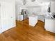 White kitchen with stainless steel appliances, an island, and hardwood floors at 3600 Sipes Ln, Charlotte, NC 28269
