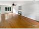 Bright living room with wood floors, fireplace, and a large window overlooking the front yard at 3600 Sipes Ln, Charlotte, NC 28269
