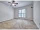 Neutral bedroom with a ceiling fan, large window, and comfortable carpet flooring at 46 Timberidge Dr, Lake Wylie, SC 29710