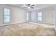 Large bedroom with neutral carpet, ceiling fan, and plantation shutters at 46 Timberidge Dr, Lake Wylie, SC 29710