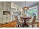 Bright breakfast nook features beautiful wood floors, custom cabinets, and a stunning stained glass light fixture at 46 Timberidge Dr, Lake Wylie, SC 29710