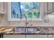 Close up of stainless steel sink with granite countertops and tiled backsplash at 46 Timberidge Dr, Lake Wylie, SC 29710