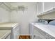 Clean laundry room with modern appliances, shelving, and storage cabinets at 46 Timberidge Dr, Lake Wylie, SC 29710