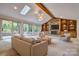 Bright living room featuring skylights, a stone fireplace, built-in shelving, and a wall of sliding glass doors at 46 Timberidge Dr, Lake Wylie, SC 29710