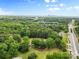 Expansive aerial view of the property featuring lush greenery, skyline in distance, and major road access at 4608 Beatties Ford Rd, Charlotte, NC 28216