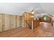 Attic space featuring wood floors and wood paneled walls, illuminated by several ceiling fans at 4608 Beatties Ford Rd, Charlotte, NC 28216
