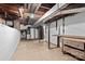 Unfinished basement with exposed pipes and beams, featuring white brick walls and concrete floors at 4608 Beatties Ford Rd, Charlotte, NC 28216