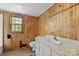 Dated bathroom with wood paneled walls, laminate countertop and flooring, plus a window at 4608 Beatties Ford Rd, Charlotte, NC 28216