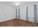 Bright bedroom featuring hardwood floors, ceiling fan, and natural light from two windows at 4608 Beatties Ford Rd, Charlotte, NC 28216