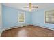 Cozy bedroom with light blue walls, hardwood floors, and two windows providing natural light at 4608 Beatties Ford Rd, Charlotte, NC 28216