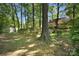 Spacious backyard with mature trees, a storage shed, and a fenced area for privacy at 4738 Truscott Rd, Charlotte, NC 28226