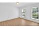 Bedroom with white walls and new flooring, featuring natural light from the two windows at 4738 Truscott Rd, Charlotte, NC 28226