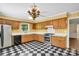 Vintage kitchen with retro charm featuring checkerboard floors and oak cabinets at 4738 Truscott Rd, Charlotte, NC 28226