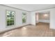 Laminate floors in living room, leading to dining area, filled with natural light from large windows at 4738 Truscott Rd, Charlotte, NC 28226