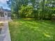 This sprawling backyard features mature trees and lush green grass at 5013 Prestwick Ln, Charlotte, NC 28212