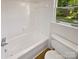 Bright bathroom featuring a white tub with tiled walls and a window view at 5013 Prestwick Ln, Charlotte, NC 28212