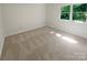 A bright and airy bedroom featuring plush carpeting and natural light from a large window at 5013 Prestwick Ln, Charlotte, NC 28212