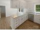 Galley kitchen features white cabinets, stainless steel appliances, and lots of natural light at 5013 Prestwick Ln, Charlotte, NC 28212