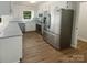 Modern kitchen with stainless steel appliances, white cabinets, and a view of the backyard at 5013 Prestwick Ln, Charlotte, NC 28212