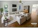 Bright living room features a brick fireplace, stylish furniture and decor, and wood floors at 5013 Prestwick Ln, Charlotte, NC 28212