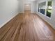 Spacious living room featuring gleaming hardwood floors, large windows, and an open floorplan at 5013 Prestwick Ln, Charlotte, NC 28212