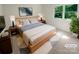 Cozy primary bedroom with a large window, stylish decor, and comfortable furnishings at 5013 Prestwick Ln, Charlotte, NC 28212