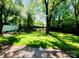 Private backyard is grassy with plenty of shade trees at 509 North St, Belmont, NC 28012