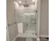 Modern shower with glass doors, a rainfall showerhead, and pristine white tiling at 5118 Regents Park Dr, Hickory, NC 28602