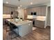Modern kitchen with a large island, stainless steel appliances, granite countertops, and stylish lighting at 5118 Regents Park Dr, Hickory, NC 28602