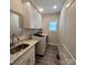 A laundry room features a utility sink, granite countertops, washer, dryer, and white cabinets for all your laundry needs at 5118 Regents Park Dr, Hickory, NC 28602
