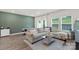 Open-concept living room with stylish sectional sofa, green accent wall, and dining area at 518 Tayberry Ln, Fort Mill, SC 29715