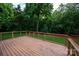 A wooden backyard deck with wire railings looks out into a lush, green space at 601 Carver Pond Ln, Waxhaw, NC 28173
